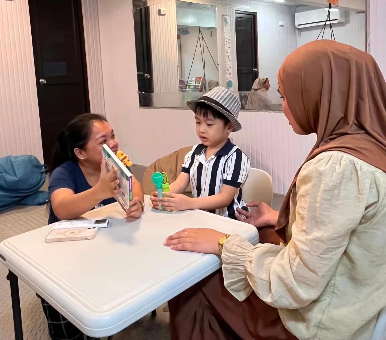 A therapist reading with a child at Little BLOOM